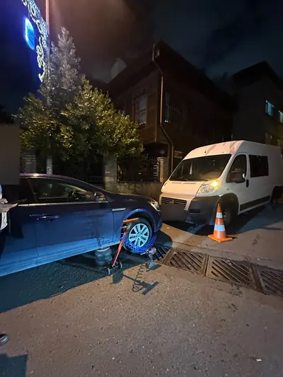 Gece sokakta sedan aracın ön lastiğine yerinde tamir