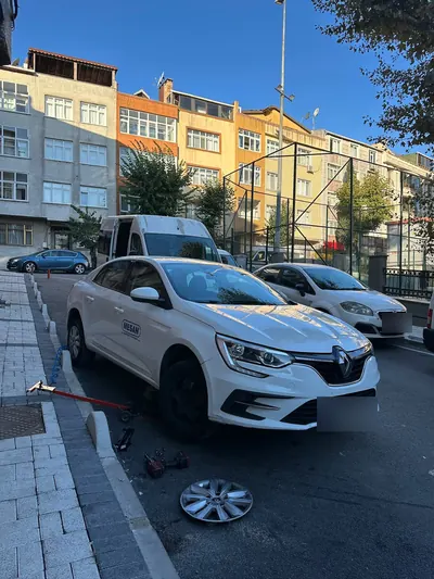 Gündüz sokakta sedan aracın sökülmüş ön tekeri ve lastik değişimi