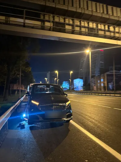 Gece üst geçit altında, ana yol kenarında kalan araca lastik yardımı
