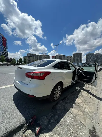 Ana yol kenarında beyaz sedan aracın lastik değişimi