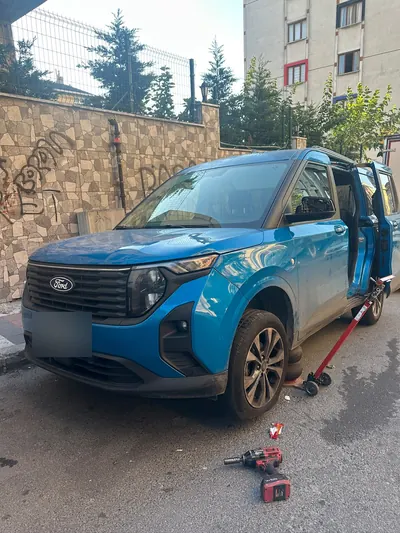 Sokakta pikap aracın ön lastiğinin krikoyla kaldırılması