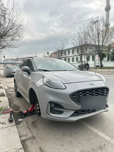 Gündüz yol kenarında crossover aracın ön tekerine kriko ile müdahale