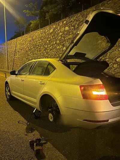 Gece arka tekeri sökülmüş sedan araçta lastik tamiri